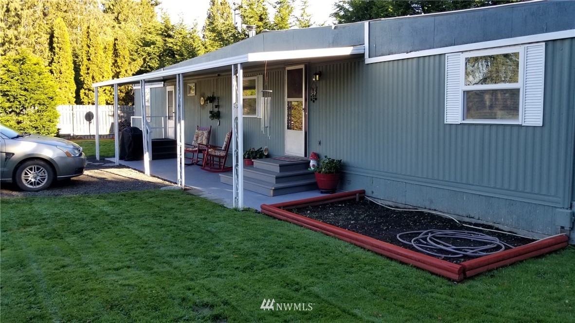 171 Spath Road Sequim, WA 98382 - Photo 3 of 21 a backyard of a house with wooden table and chairs