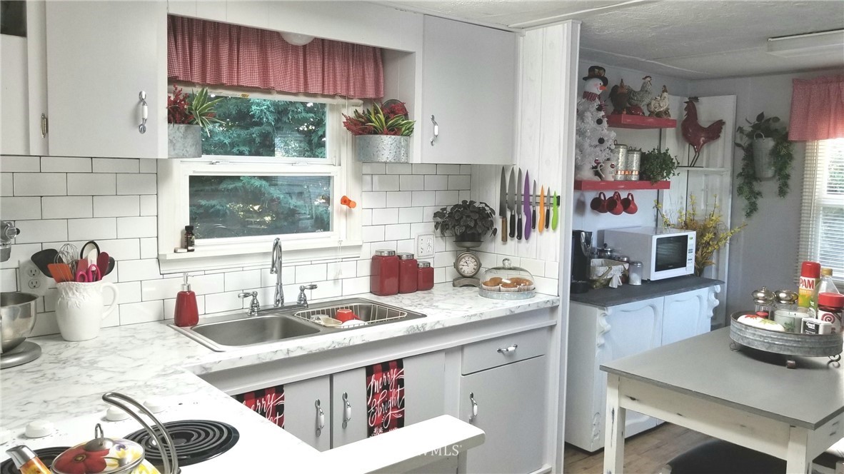 171 Spath Road Sequim, WA 98382 - Photo 6 of 21 a kitchen with a sink cabinets and a stove top oven