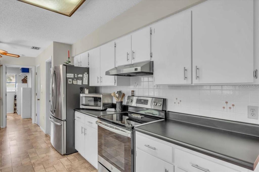 331 Burke Road Venice, FL 34293 - Photo 11 of 29 a kitchen with stainless steel appliances granite countertop a sink a stove and a refrigerator