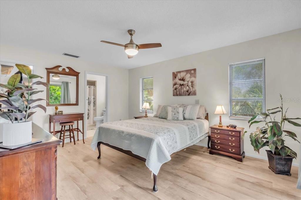 331 Burke Road Venice, FL 34293 - Photo 14 of 29 a spacious bedroom with a bed a dresser and wooden floor