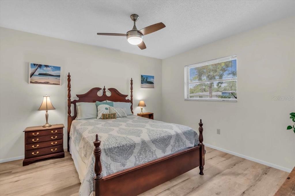 331 Burke Road Venice, FL 34293 - Photo 19 of 29 a bedroom with a bed a dresser and wooden floor