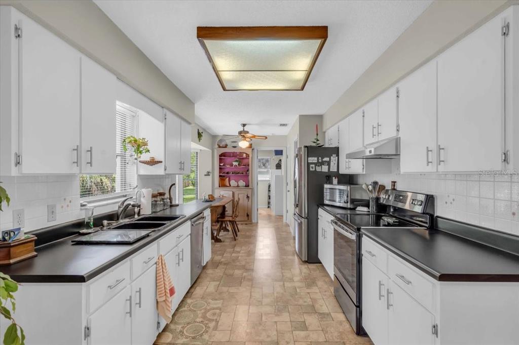 331 Burke Road Venice, FL 34293 - Photo 9 of 29 a kitchen with stainless steel appliances a sink stove top oven and cabinets