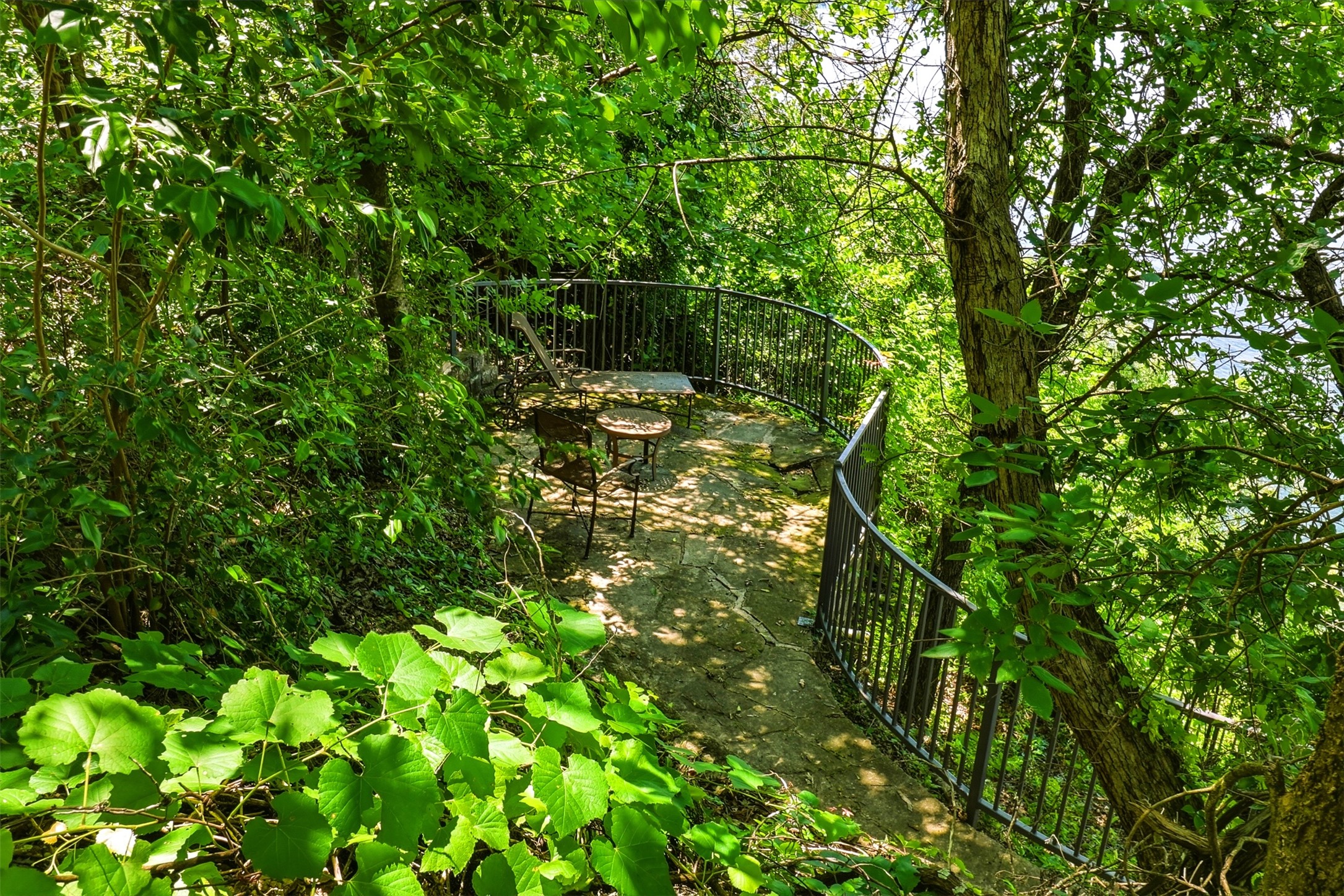 2918 Ranch Road 620, Unit 265 Austin, TX 78734 - Photo 33 of 40 A secluded outdoor patio, nestled amidst lush greenery, offers a tranquil escape.