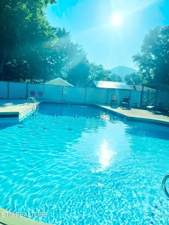a view of backyard with swimming pool and outdoor seating