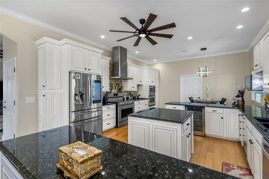 4613 Harborpointe Drive Port Richey, FL 34668 - Photo 18 of 21 a kitchen with stainless steel appliances kitchen island granite countertop a sink stove and refrigerator