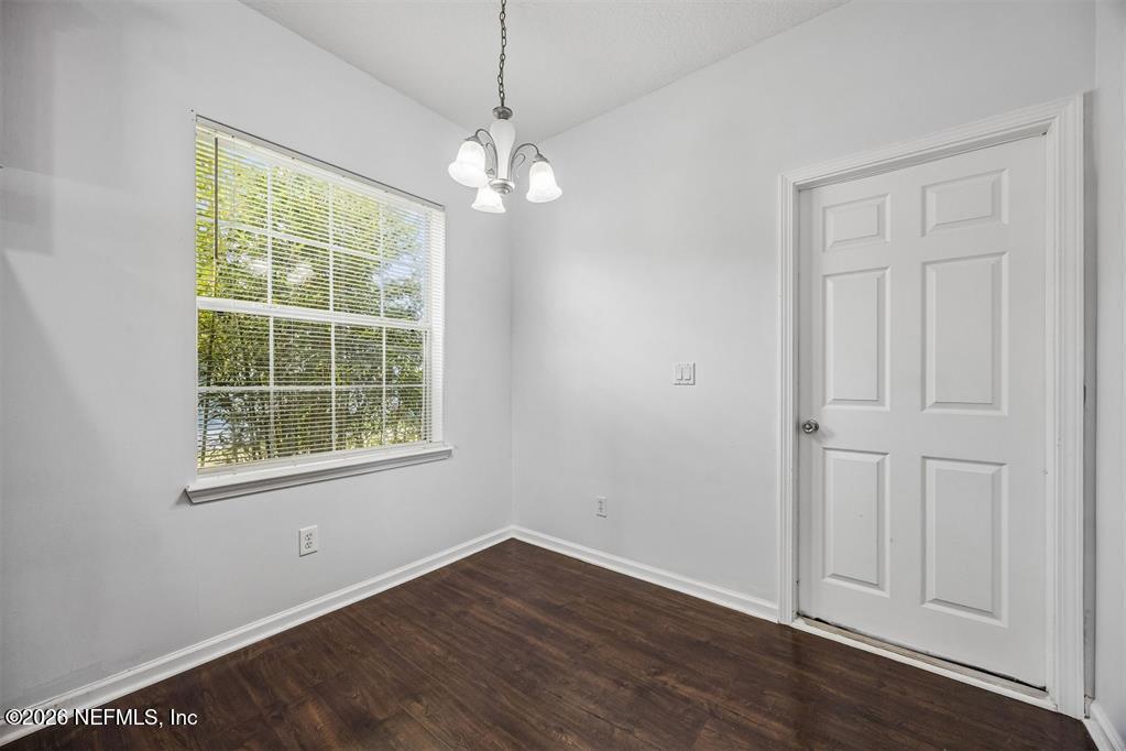 96204 Coral Reef Road Yulee, FL 32097 - Photo 17 of 40 an empty room with wooden floor and windows