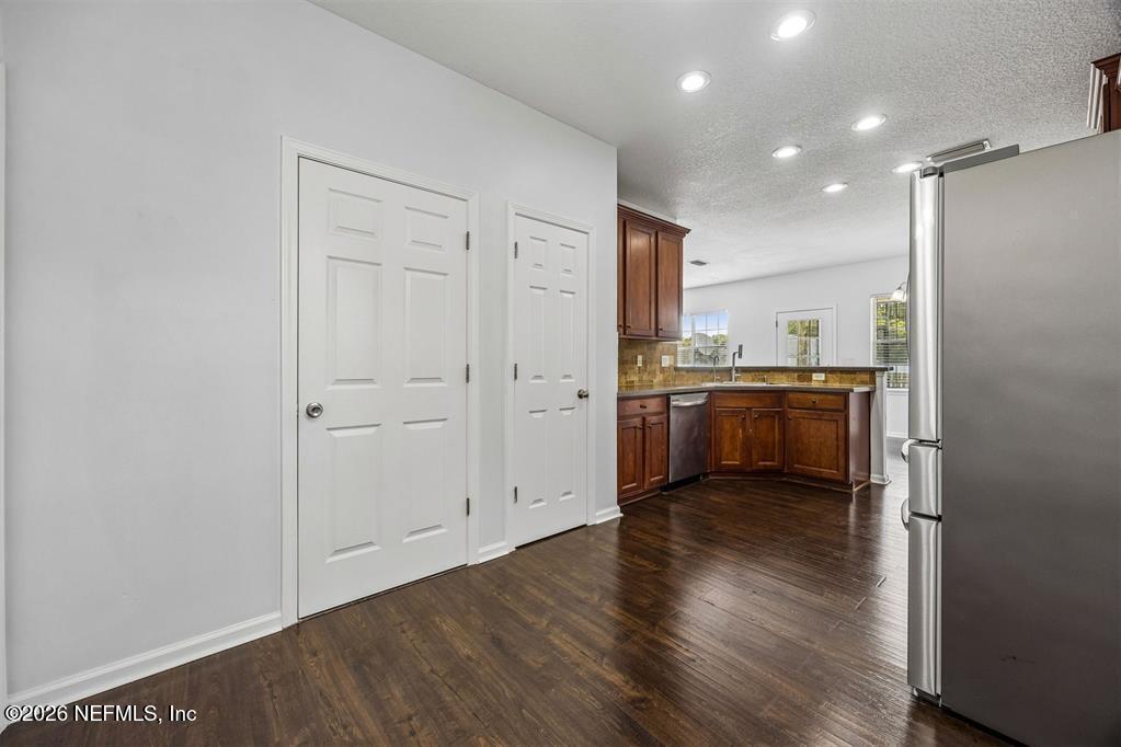 96204 Coral Reef Road Yulee, FL 32097 - Photo 18 of 40 a view of a kitchen with a sink and dishwasher a refrigerator with wooden floor