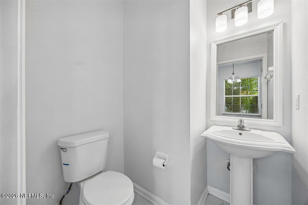 96204 Coral Reef Road Yulee, FL 32097 - Photo 19 of 40 a bathroom with a sink mirror and toilet