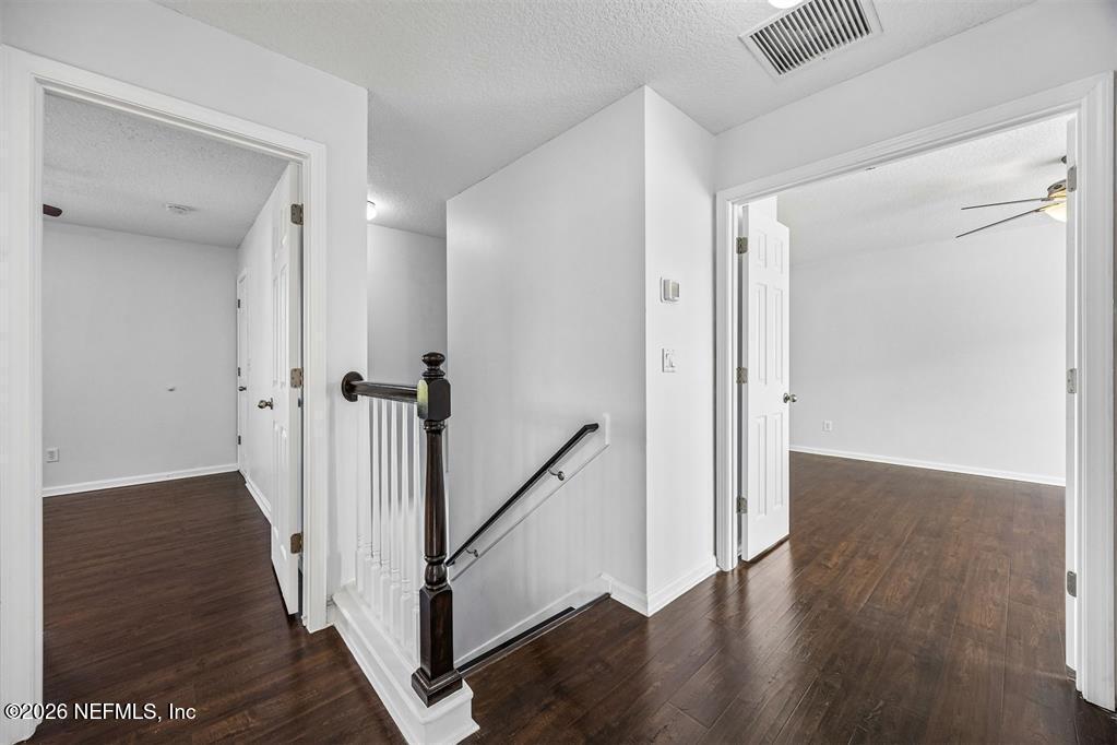 96204 Coral Reef Road Yulee, FL 32097 - Photo 21 of 40 a view of a hallway with wooden floor and staircase