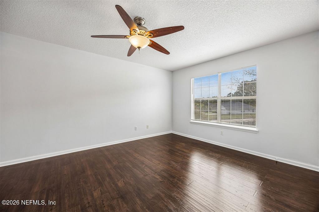 96204 Coral Reef Road Yulee, FL 32097 - Photo 22 of 40 a view of an empty room with wooden floor and a window
