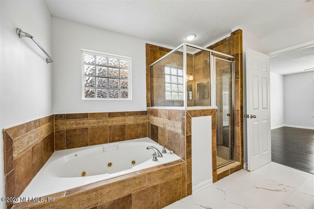 96204 Coral Reef Road Yulee, FL 32097 - Photo 24 of 40 a bathroom with a bathtub and a shower