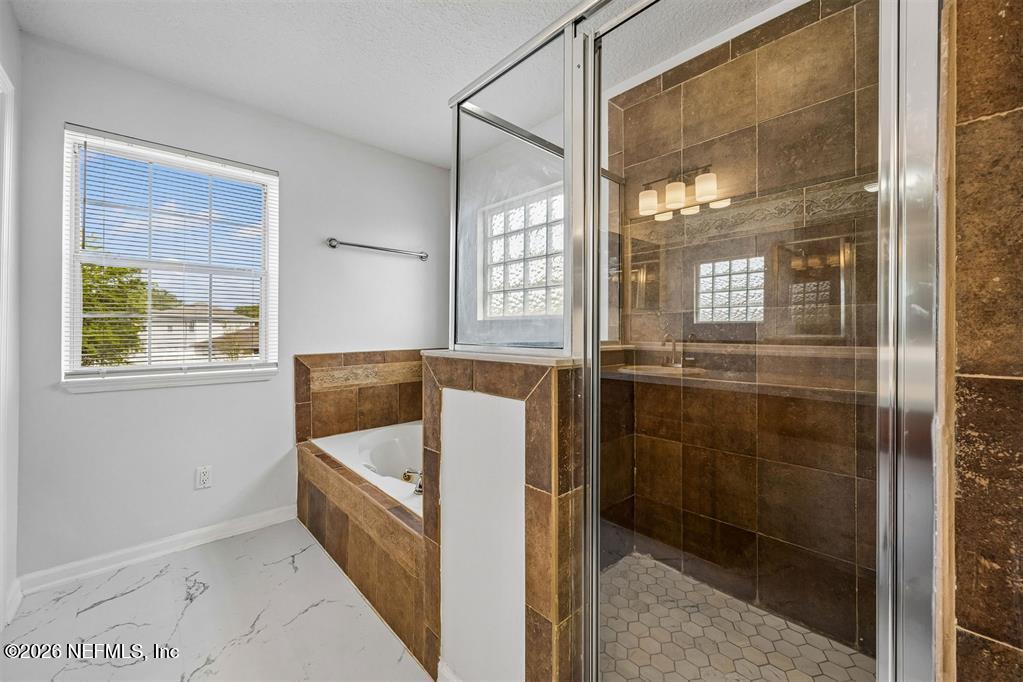 96204 Coral Reef Road Yulee, FL 32097 - Photo 25 of 40 a bathroom with a tub and shower