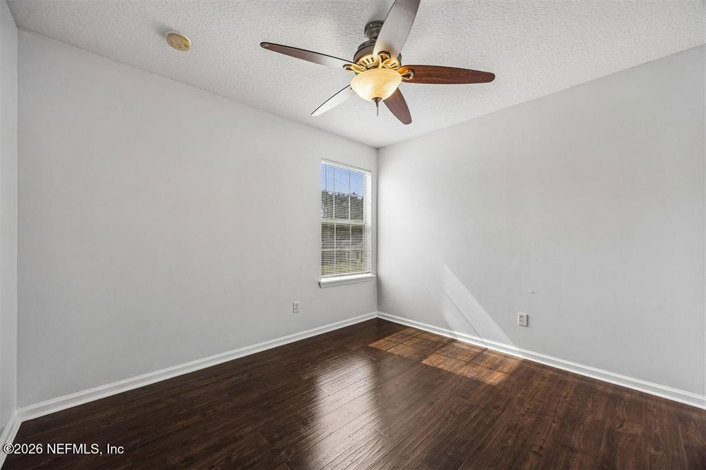 96204 Coral Reef Road Yulee, FL 32097 - Photo 27 of 40 an empty room with wooden floor and windows