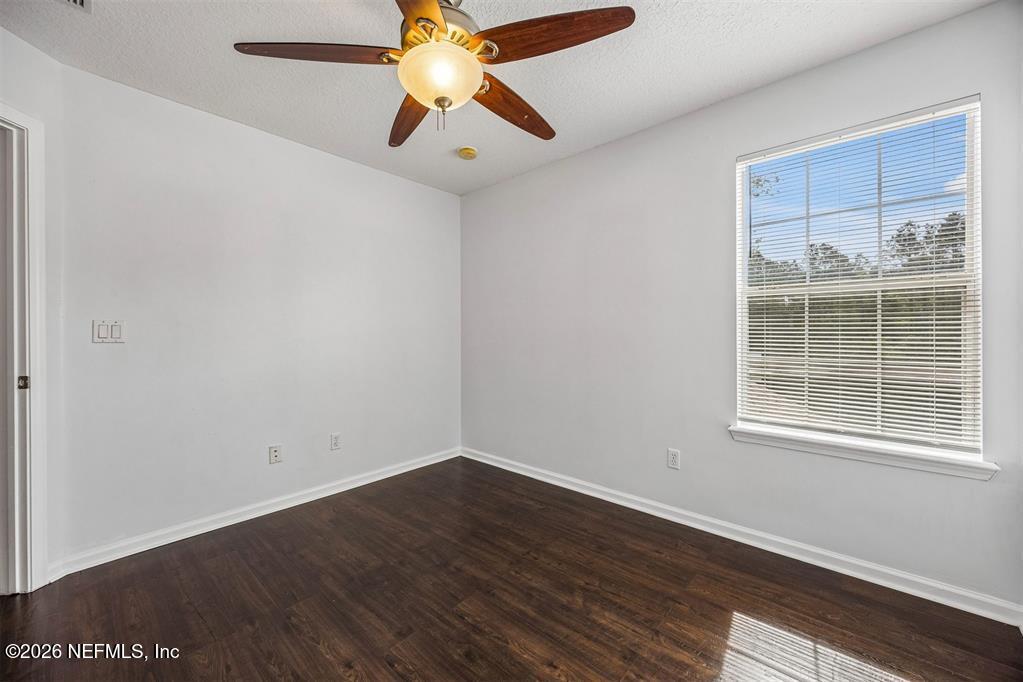 96204 Coral Reef Road Yulee, FL 32097 - Photo 28 of 40 an empty room with wooden floor and windows