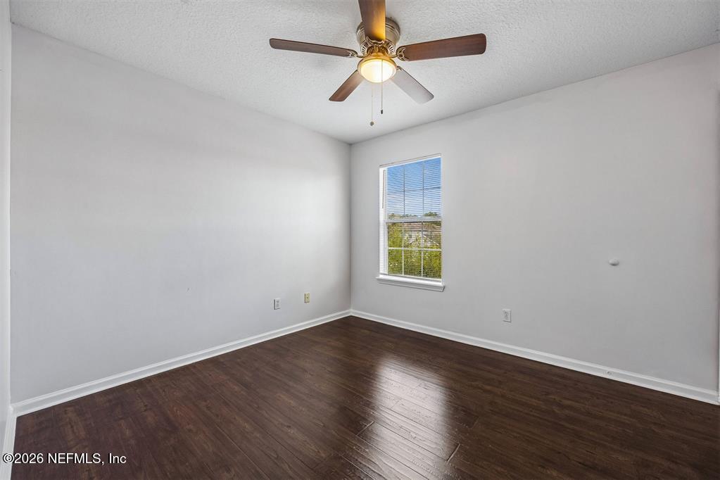 96204 Coral Reef Road Yulee, FL 32097 - Photo 30 of 40 an empty room with wooden floor and windows