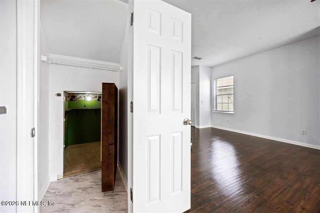 96204 Coral Reef Road Yulee, FL 32097 - Photo 32 of 40 an empty room with wooden floor and closet