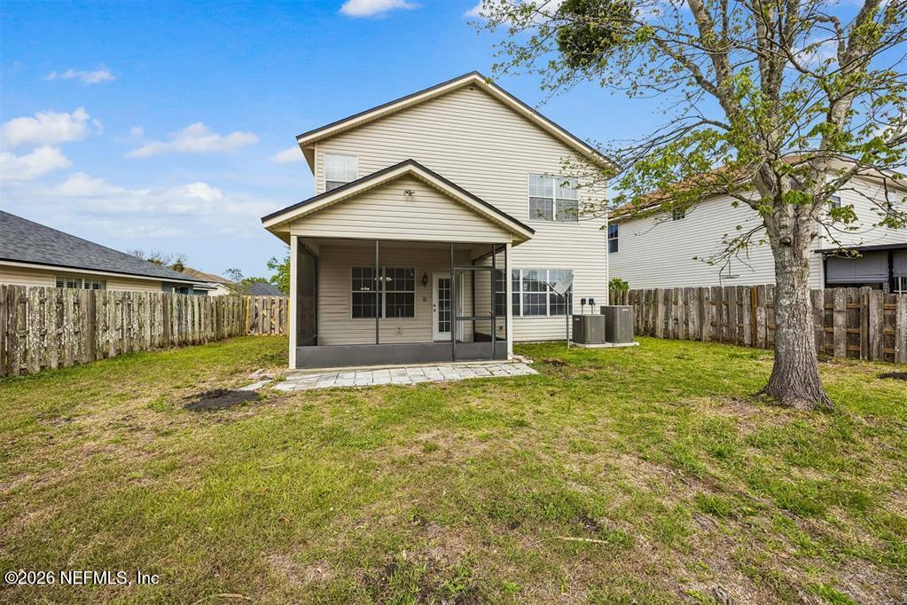 96204 Coral Reef Road Yulee, FL 32097 - Photo 35 of 40 a view of a house with floor to ceiling windows and a yard