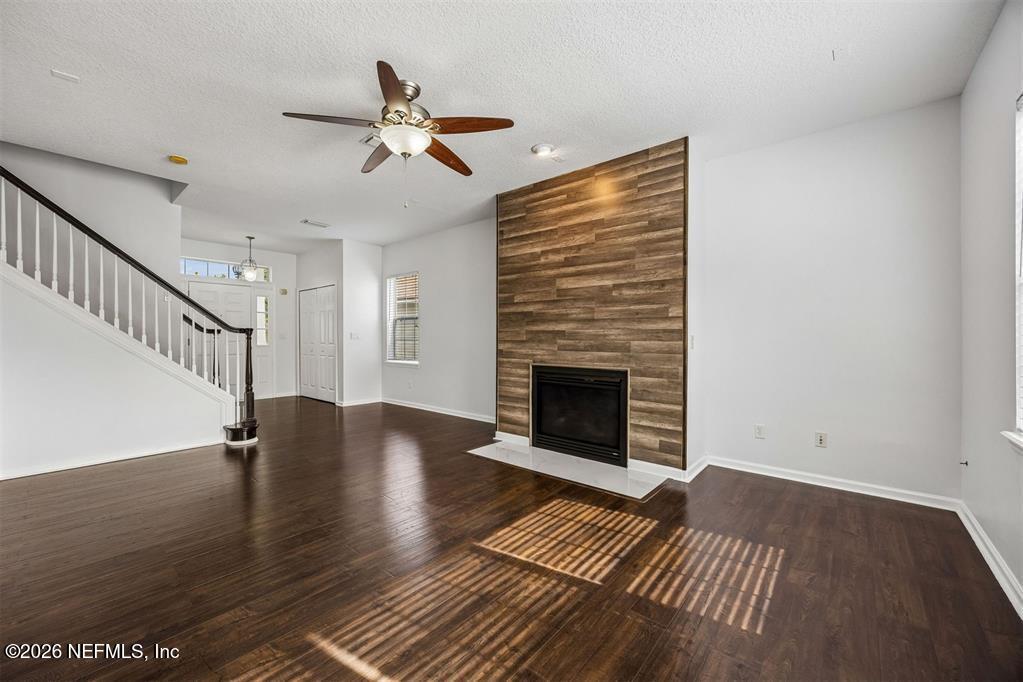 96204 Coral Reef Road Yulee, FL 32097 - Photo 9 of 40 a view of an empty room with wooden floor a fireplace and a window