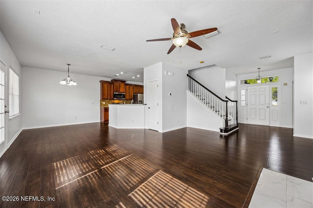 96204 Coral Reef Road Yulee, FL 32097 - Photo 10 of 40 a view of an empty room with wooden floor and a ceiling fan
