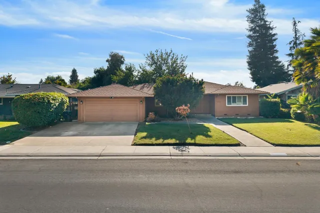 front view of house with a yard and potted plants