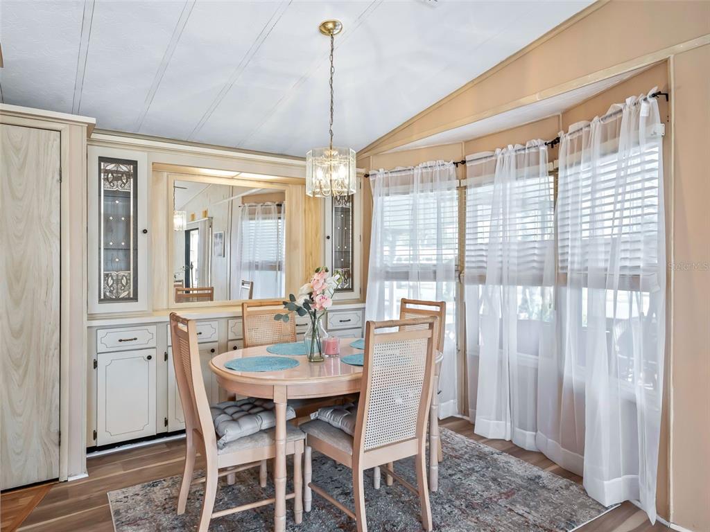 1102 Dustin Drive The Villages, FL 32159 - Photo 15 of 38 a dining room with furniture a chandelier and wooden floor