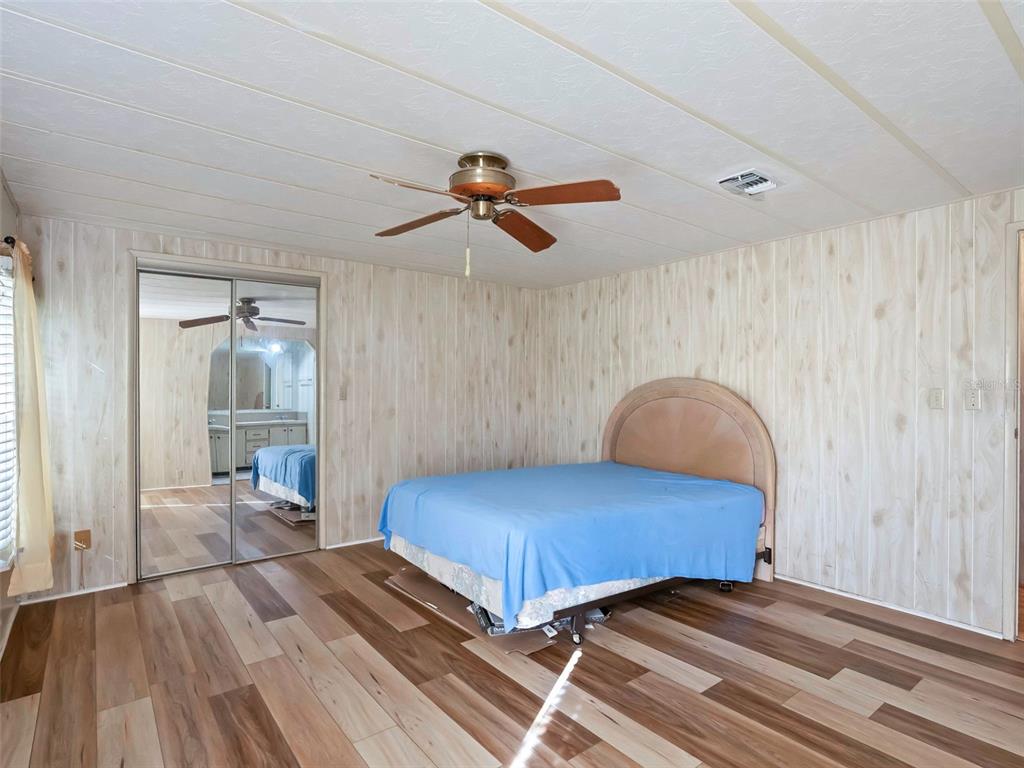 1102 Dustin Drive The Villages, FL 32159 - Photo 19 of 38 a bedroom with a bed and a chandelier