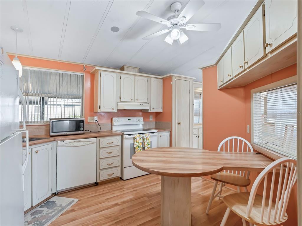 1102 Dustin Drive The Villages, FL 32159 - Photo 7 of 38 a kitchen with granite countertop a sink a center island stainless steel appliances cabinets and a window