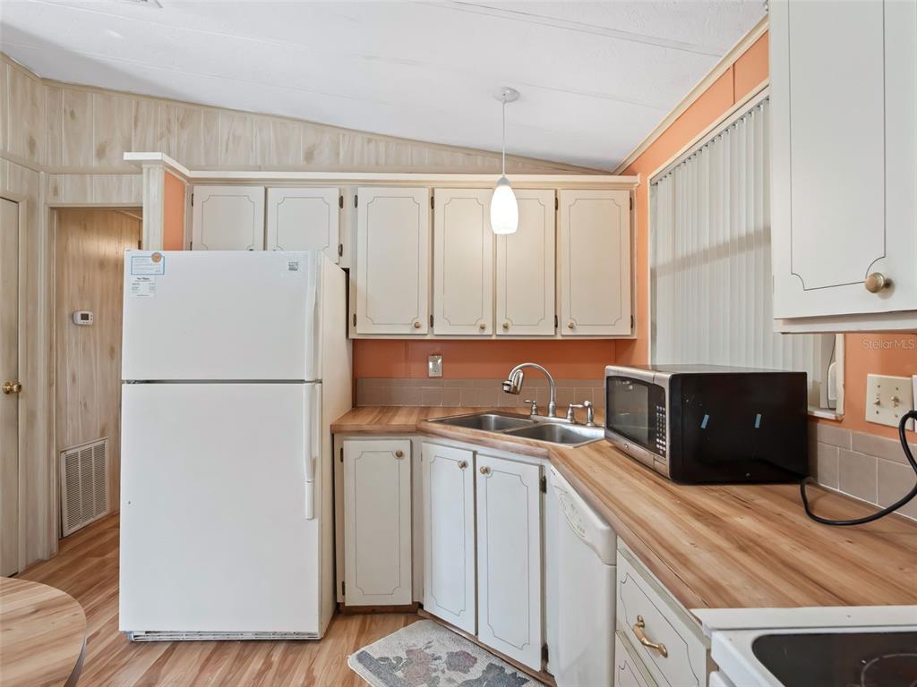 1102 Dustin Drive The Villages, FL 32159 - Photo 9 of 38 a kitchen with a refrigerator sink and cabinets