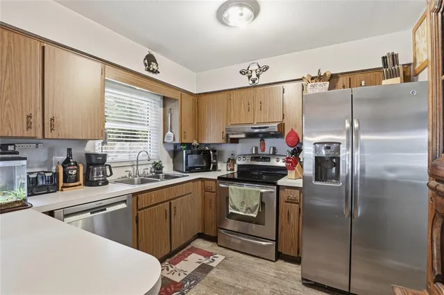 a kitchen with a sink a refrigerator and window