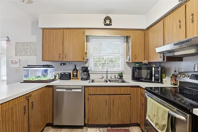 a kitchen with a sink stove top oven and cabinets