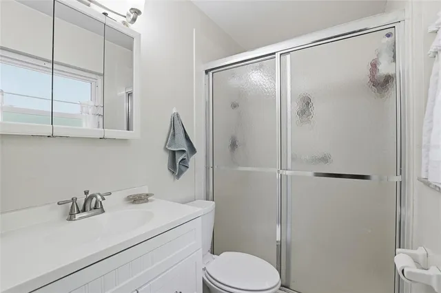 a bathroom with a sink vanity mirror and toilet