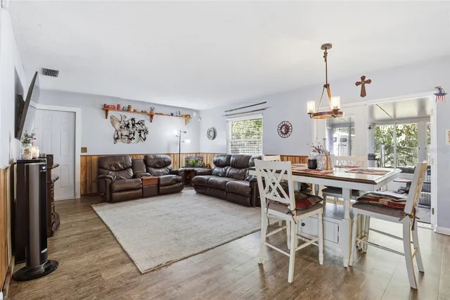 a living room with furniture a large window and a chandelier