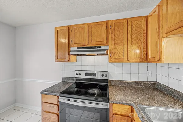 a kitchen with a stove and white cabinets