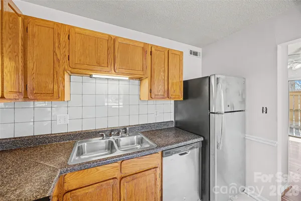a kitchen with stainless steel appliances granite countertop a refrigerator sink and cabinets