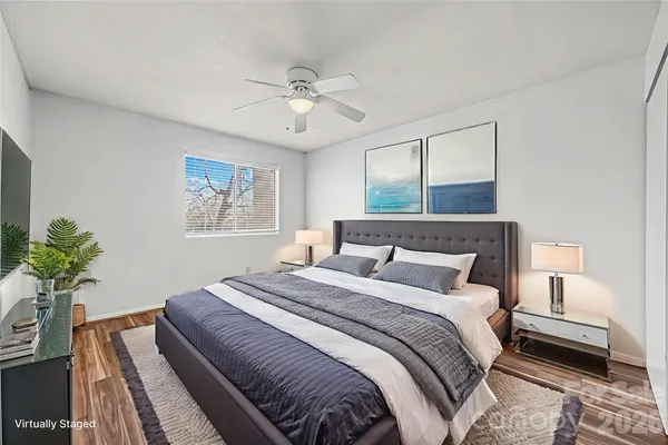 a bedroom with a large bed chandelier and a window
