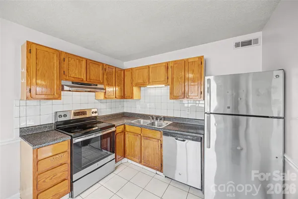 a kitchen with stainless steel appliances granite countertop a refrigerator sink and cabinets