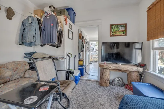 a living room with furniture and a refrigerator
