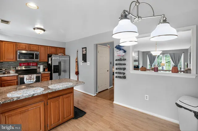 a kitchen with stainless steel appliances granite countertop a refrigerator a stove top oven a sink and dishwasher