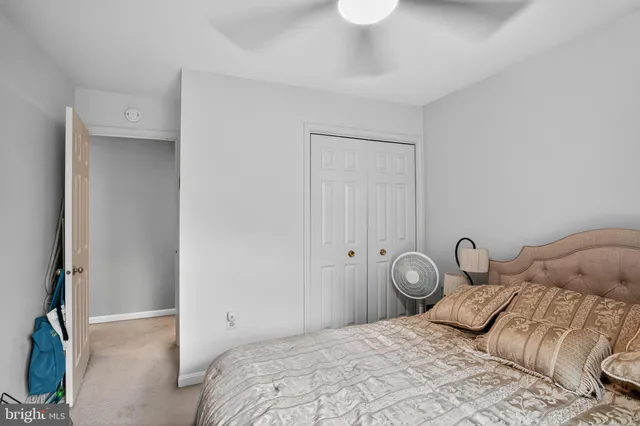 a bedroom with a bed and a closet with wooden floor