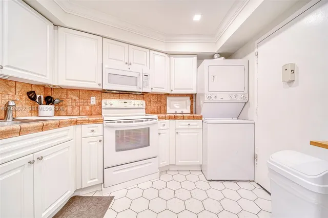a kitchen with white cabinets and white appliances