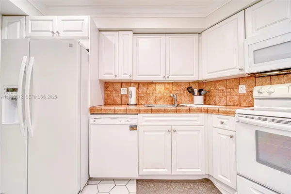 a kitchen with white cabinets and white appliances