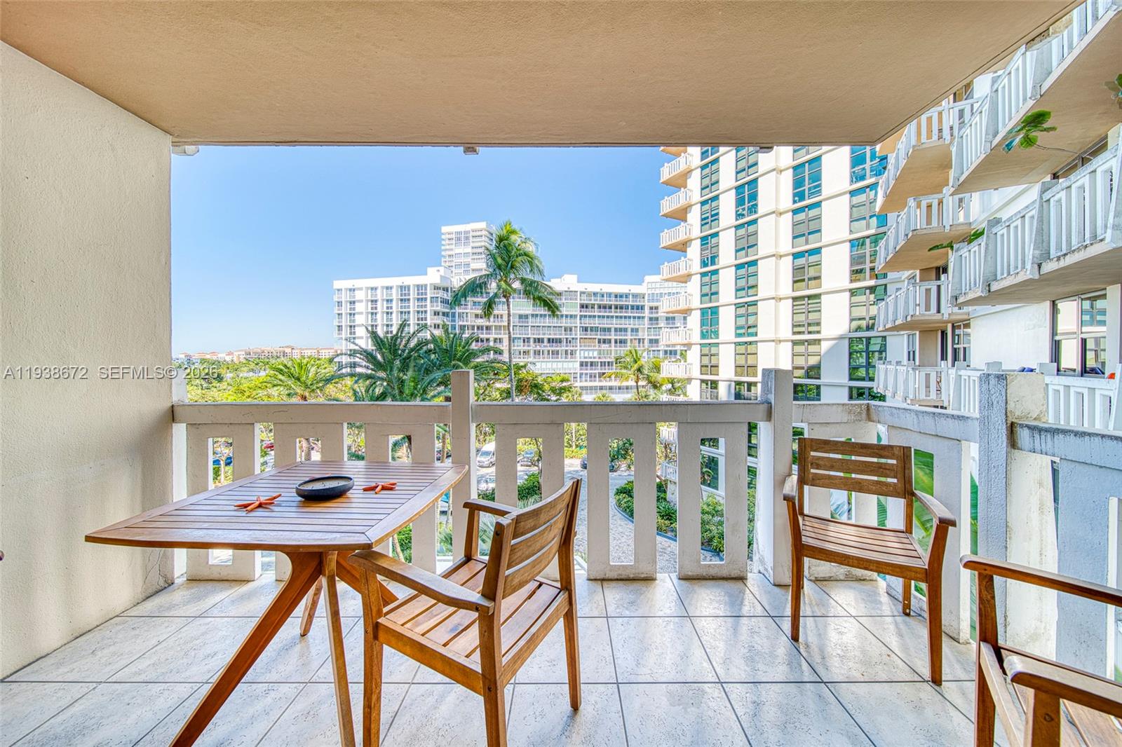 1111 Crandon Boulevard, Unit C404 Key Biscayne, FL 33149 - Photo 24 of 44 a balcony with table and chairs