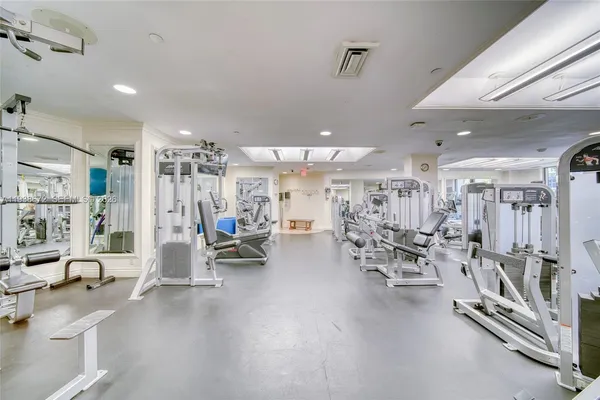 a room with gym equipment and large windows