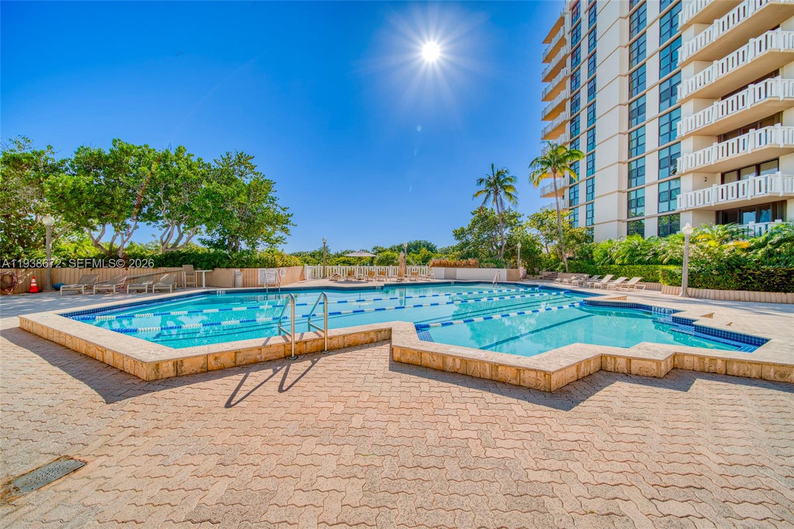 1111 Crandon Boulevard, Unit C404 Key Biscayne, FL 33149 - Photo 37 of 44 a view of a swimming pool with a lounge chairs