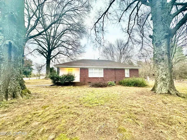 a brick house with trees in front of it