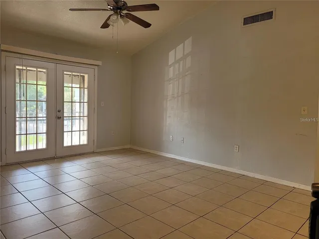 an empty room with windows and cabinet