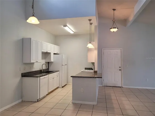 a kitchen with a sink a counter top space appliances and cabinets