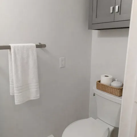 a white toilet sitting next to a shower