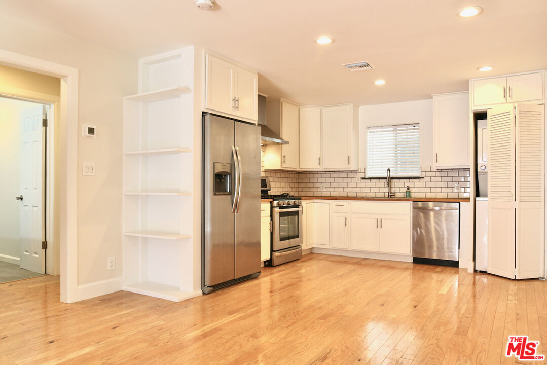 a kitchen with white cabinets and white stainless steel appliances