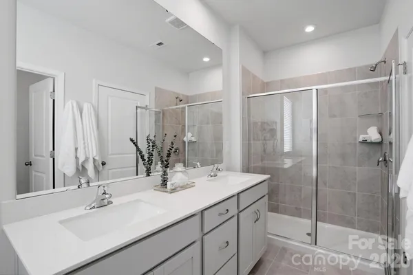 a bathroom with double vanity sink and shower